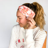 Adult women's grey headband with red and yellow drawings of Travis Kelce, his jersey number, KC Chiefs and hand-drawn hearts that says 'Go Taylor Swift's Boyfriend'