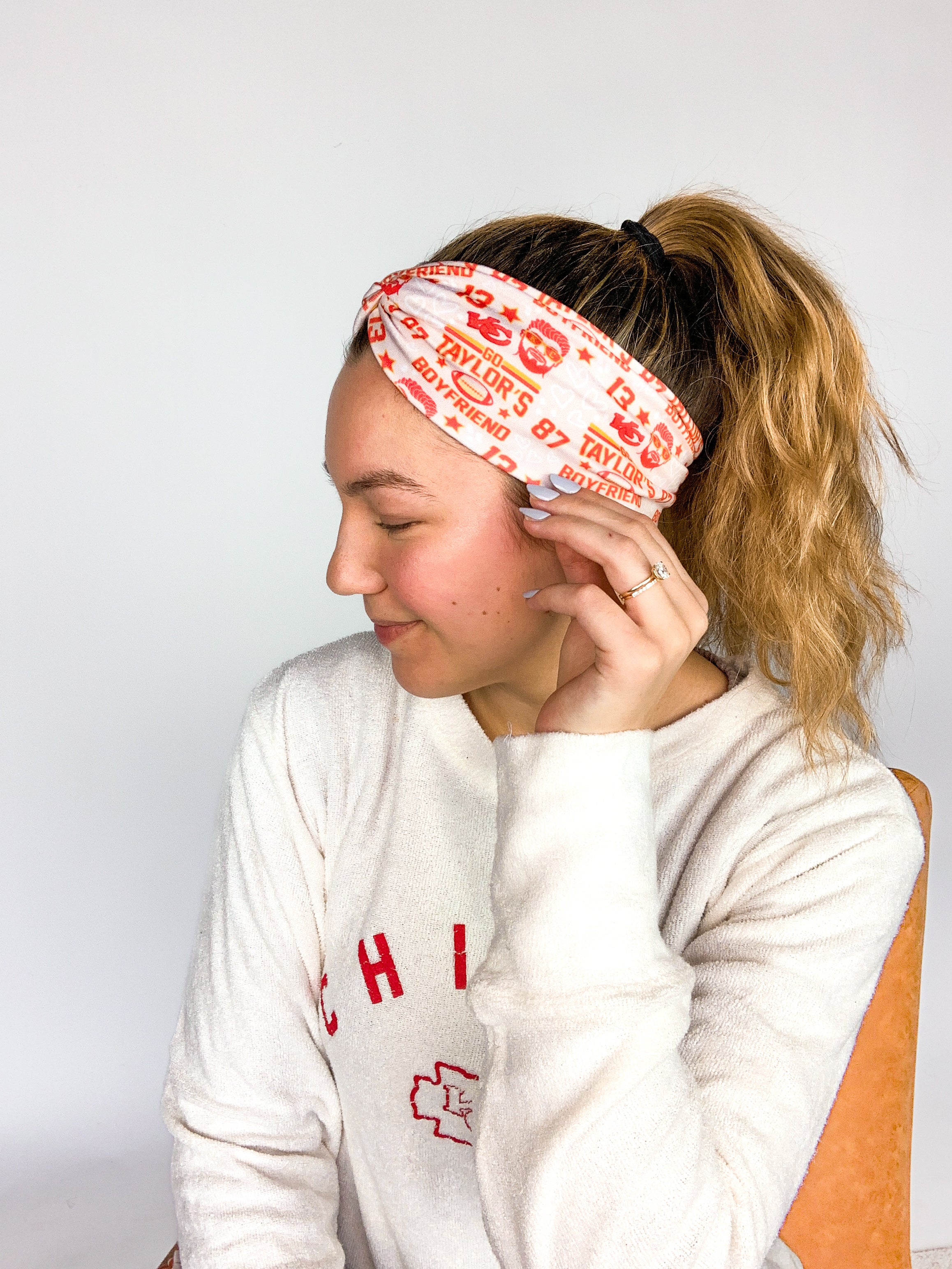 Adult women's grey headband with red and yellow drawings of Travis Kelce, his jersey number, KC Chiefs and hand-drawn hearts that says 'Go Taylor Swift's Boyfriend'