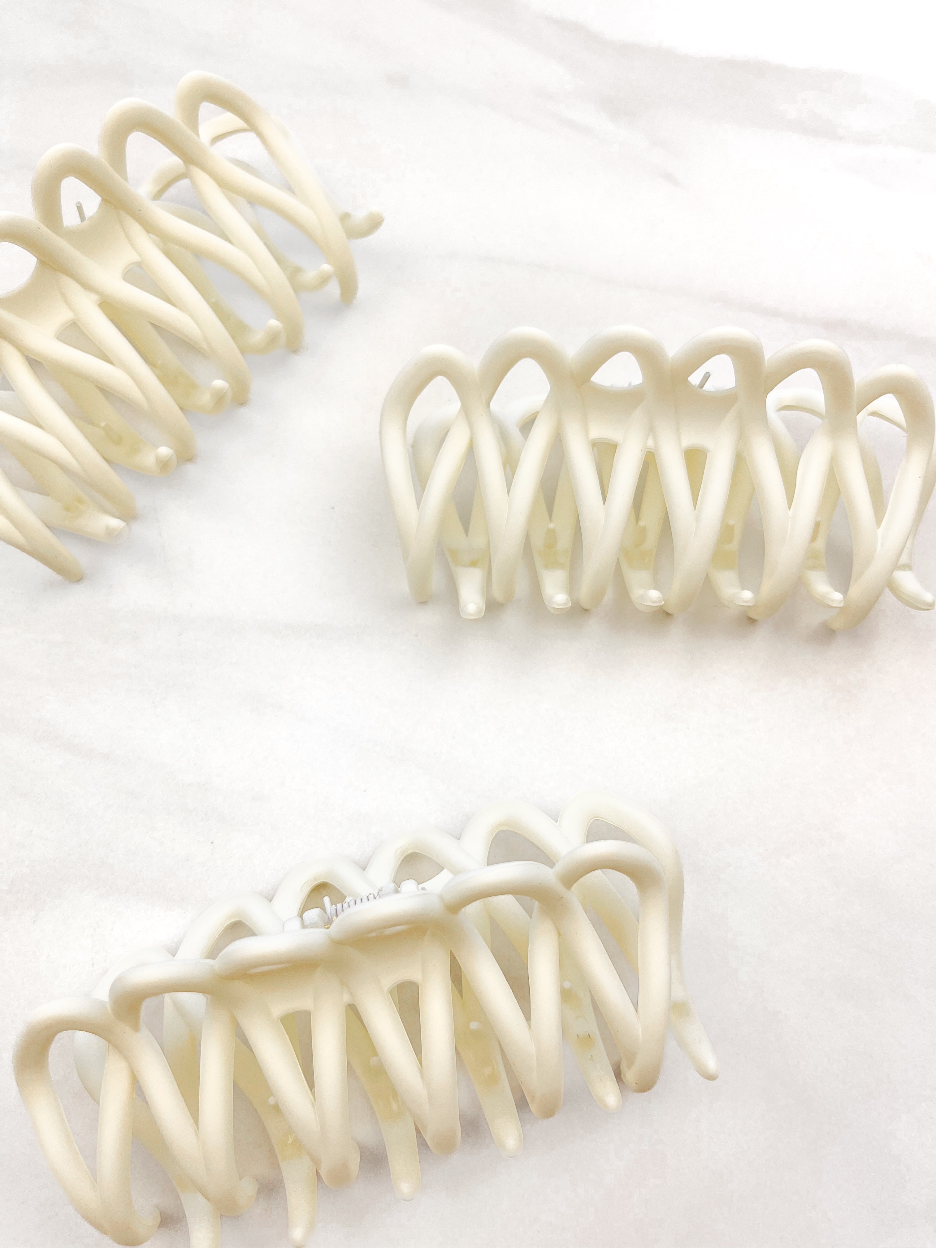 A group of loopy white hair clips, including the Take It Easy Lilac Clip, perfect for all hair types and textures. 4 inches long. Matte material. Hinge closure. Hair-out-of-face approved.