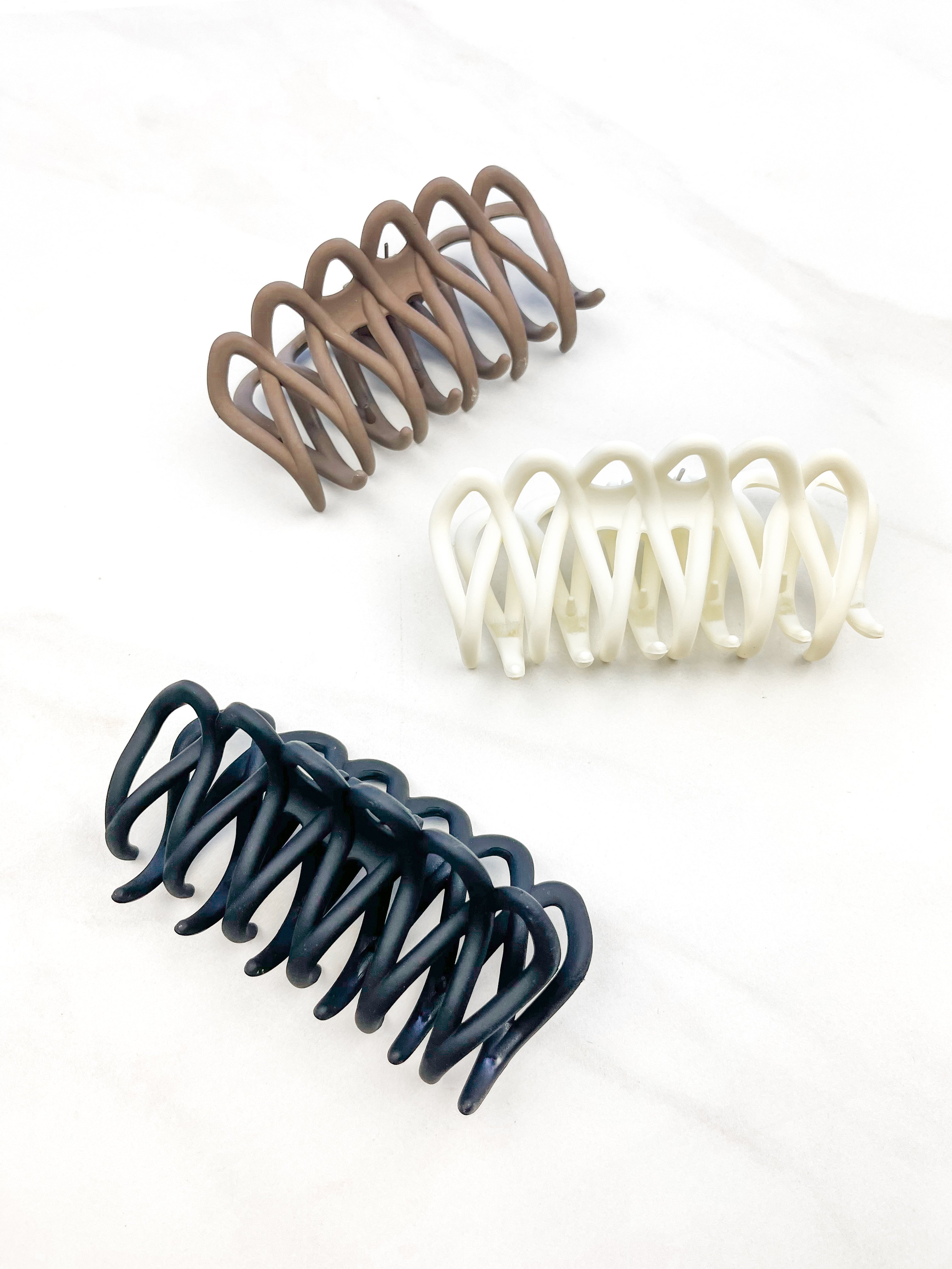 A group of loopy hair clips, including the Take It Easy Lilac Clip, perfect for all hair types and textures. 4 inches long. Matte material. Hinge closure. Hair-out-of-face approved.