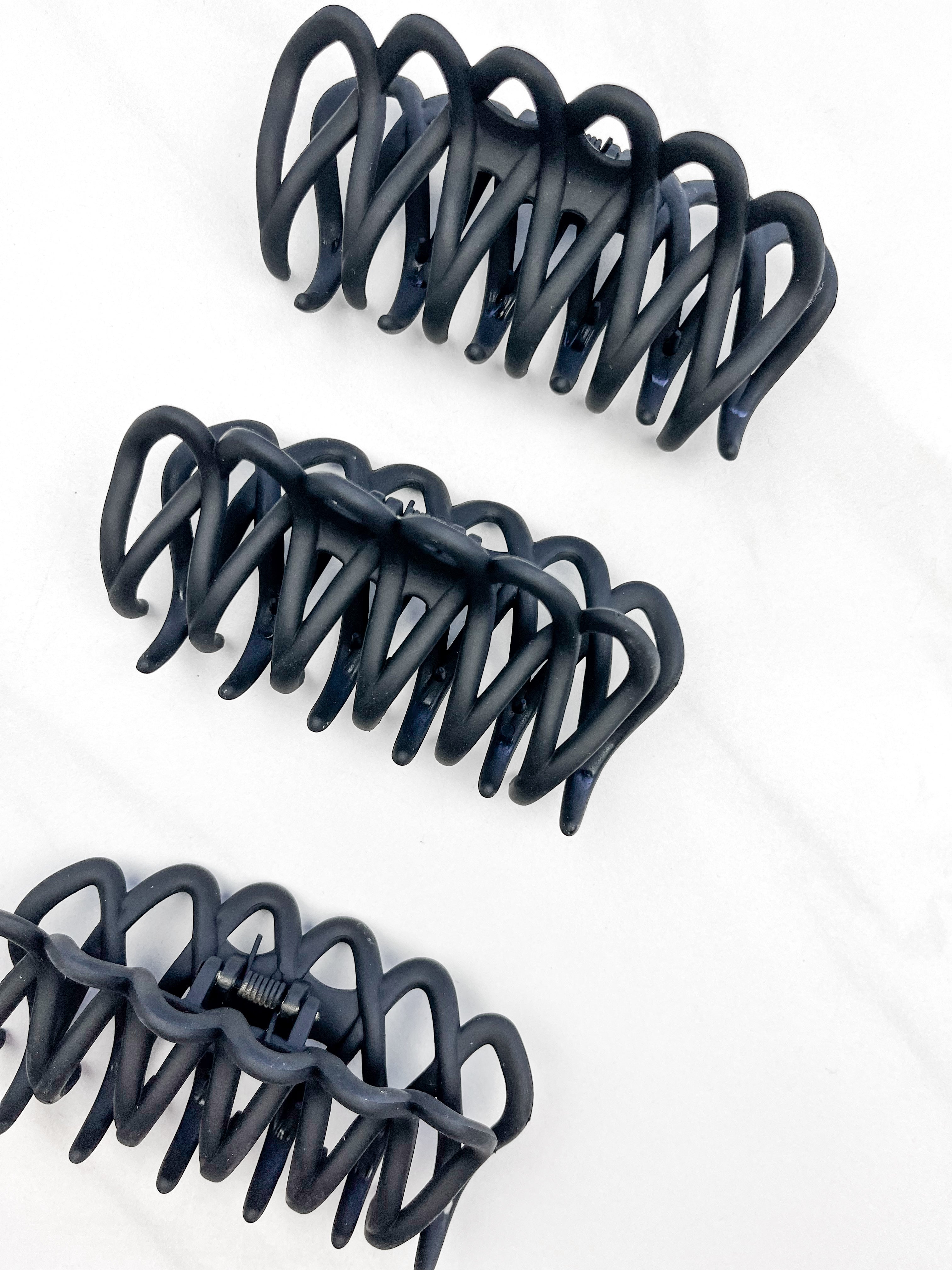 A group of loopy black hair clips, including the Take It Easy Lilac Clip, perfect for all hair types and textures. 4 inches long. Matte material. Hinge closure. Hair-out-of-face approved.