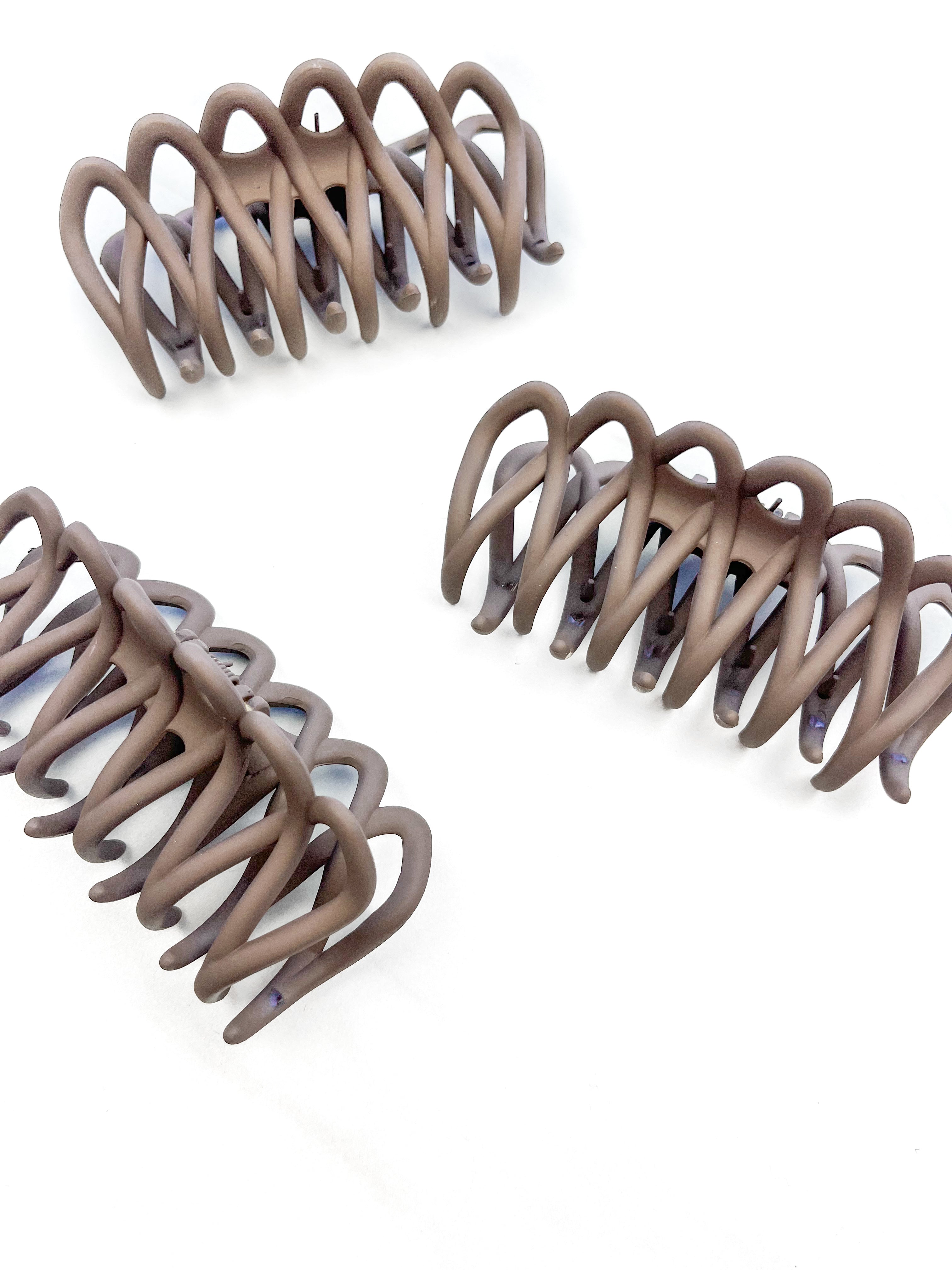 A group of loopy brown hair clips, including the Take It Easy Lilac Clip, perfect for all hair types and textures. 4 inches long. Matte material. Hinge closure. Hair-out-of-face approved.