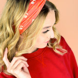  A woman wearing the red and yellow Taylor's Version headband, showcasing the football fashion accessory.