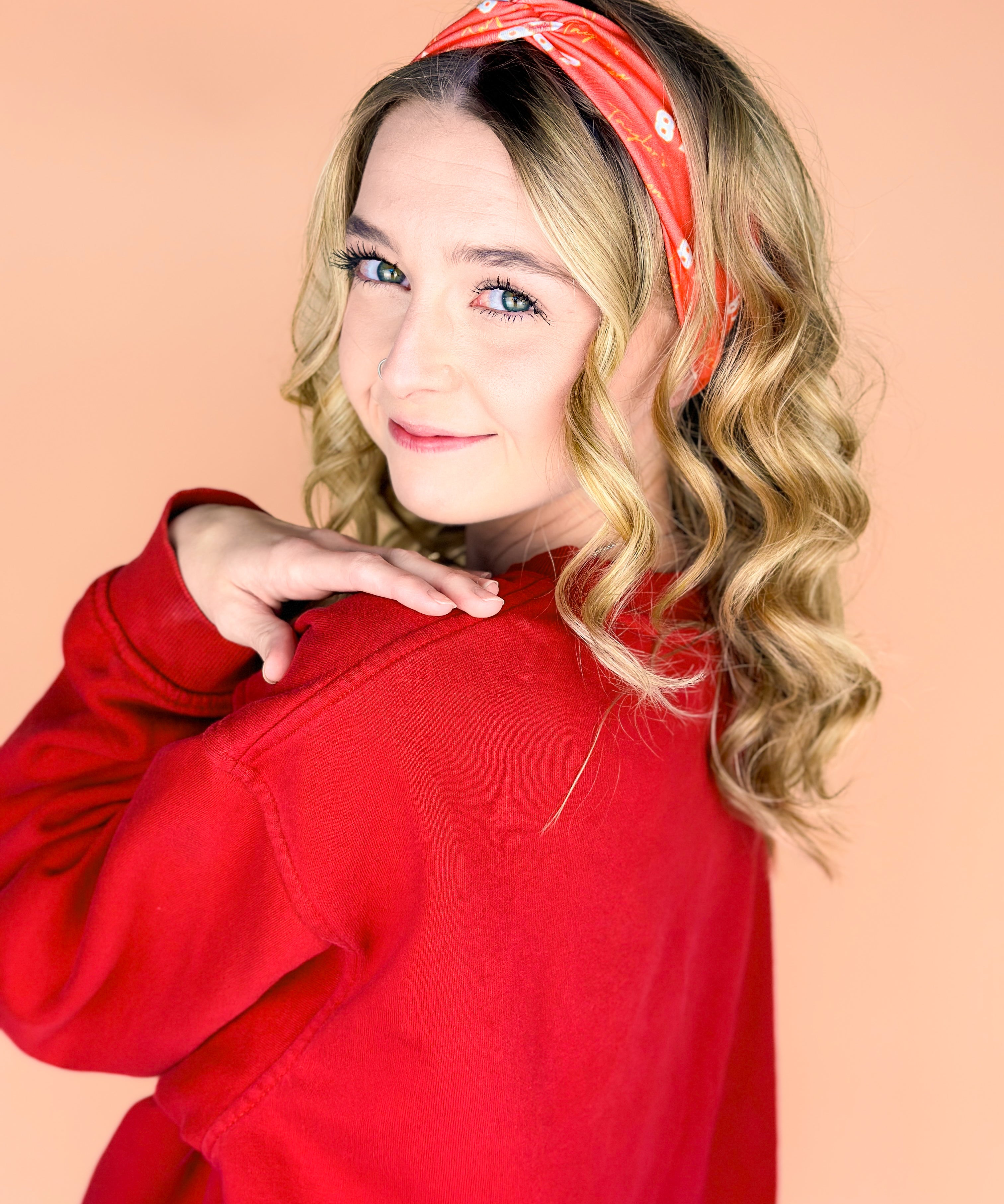  A woman wearing the red and yellow Taylor's Version headband, showcasing the football fashion accessory.