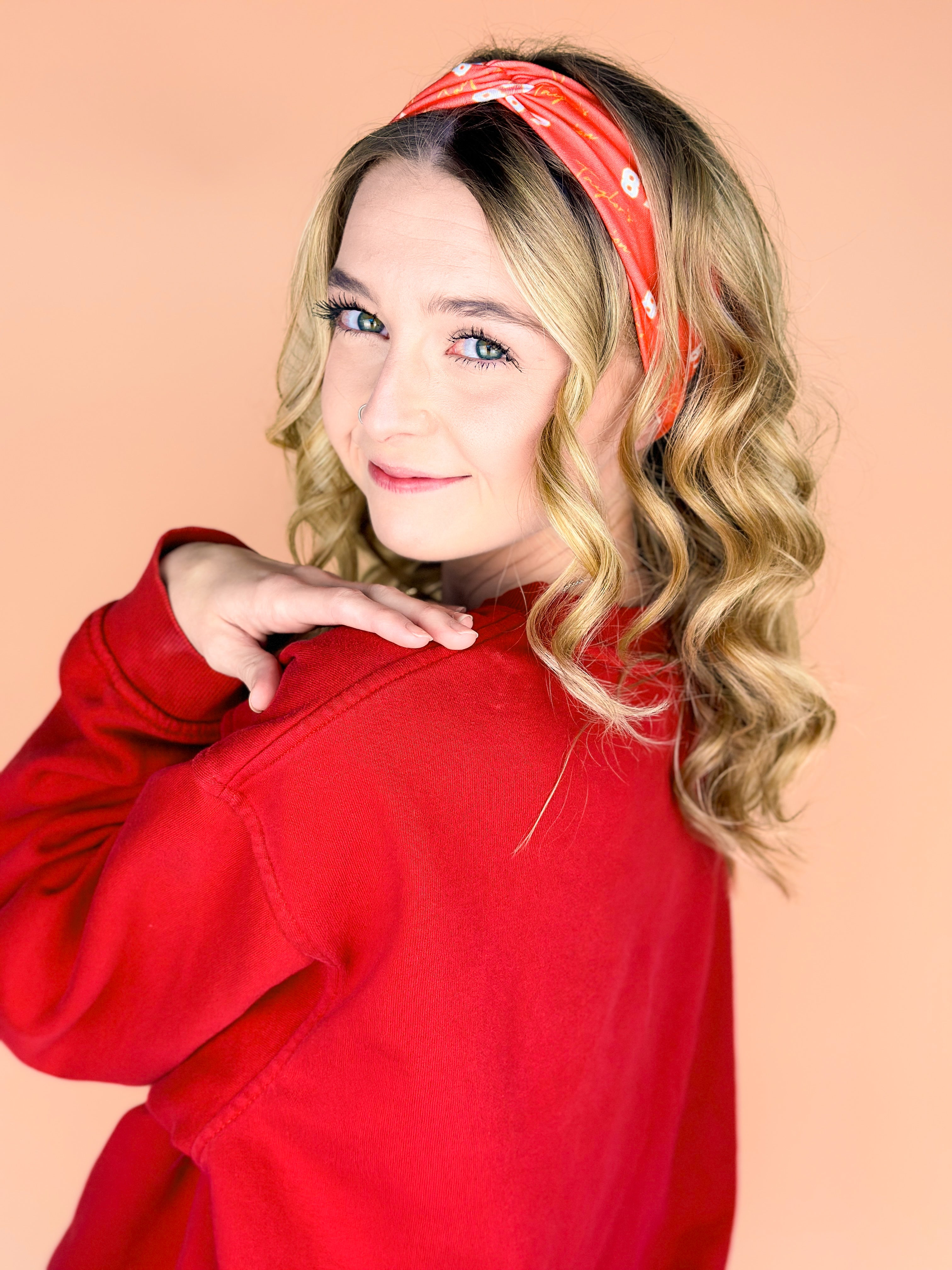  A woman wearing the red and yellow Taylor's Version headband, showcasing the football fashion accessory.