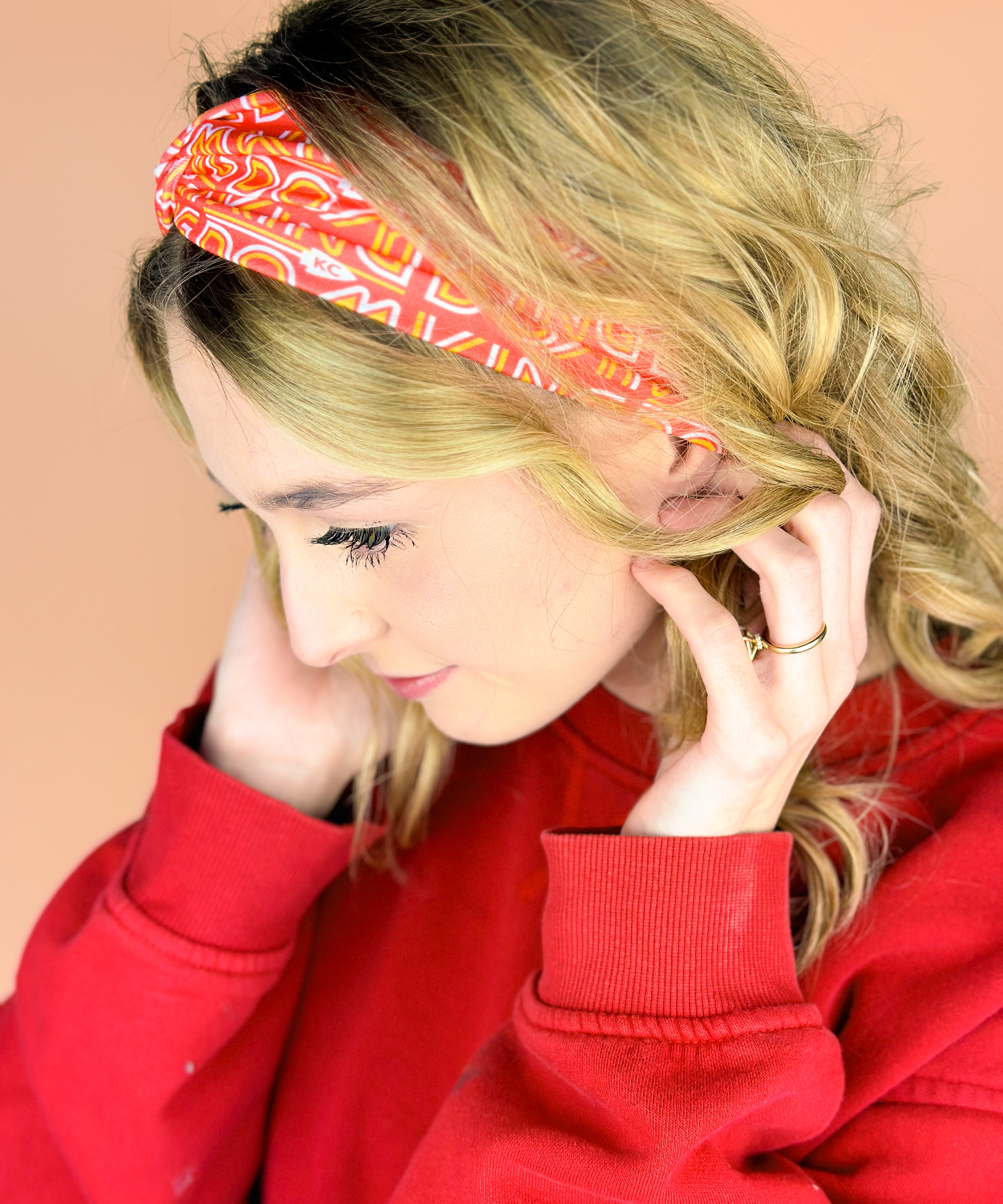  A woman wearing the red and yellow Go Big or Go Mahomes headband, showcasing the football fashion accessory.