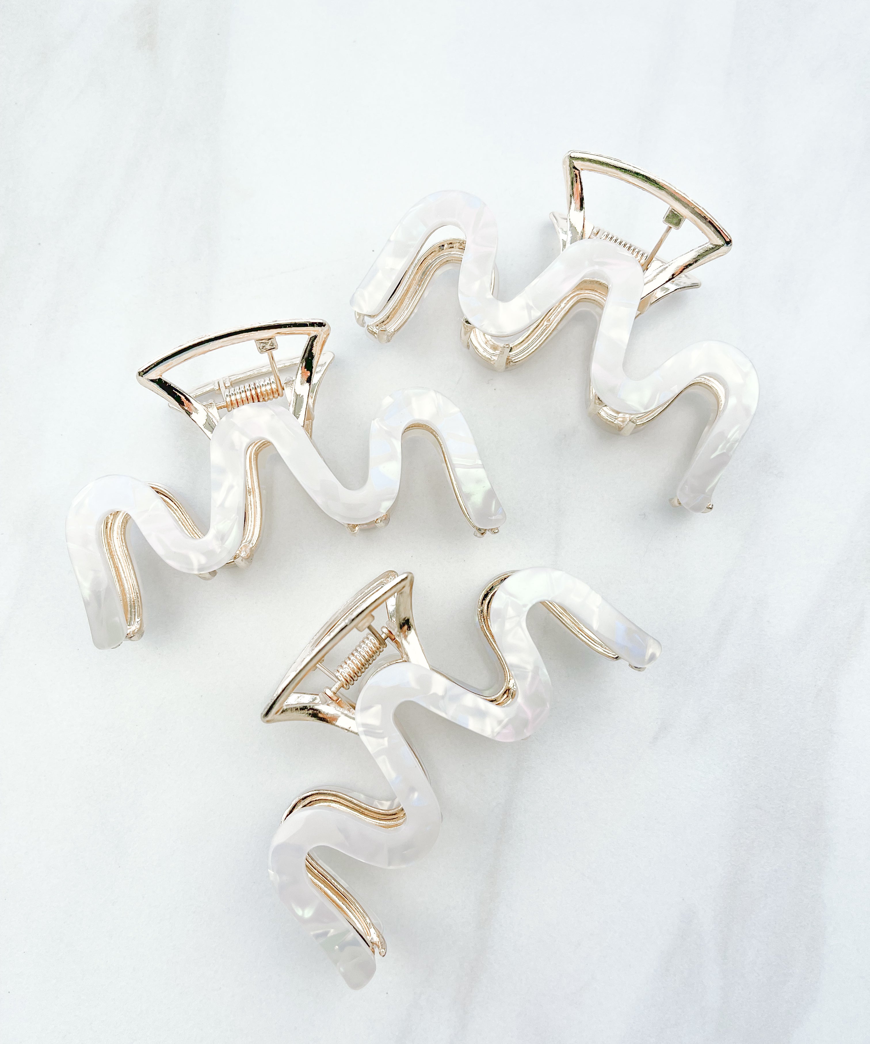 Effortless Lilac Clip, a group of hair clips with white marble and gold trim, perfect for all hair types and textures.