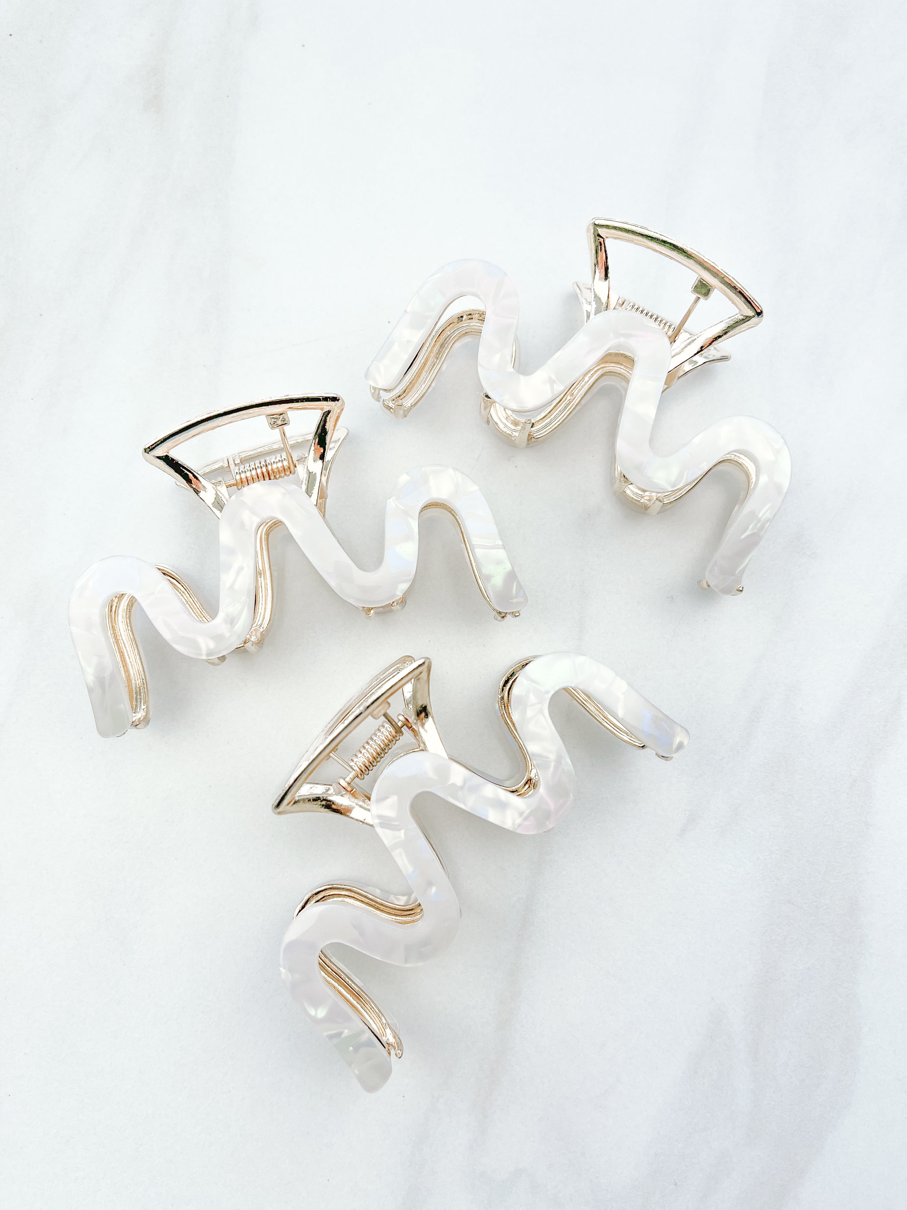 Effortless Lilac Clip, a group of hair clips with white marble and gold trim, perfect for all hair types and textures.