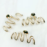 A group of zig zag-shaped gold hair clips.