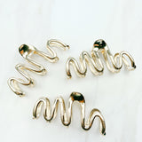 A group of zig zag-shaped gold hair clips.