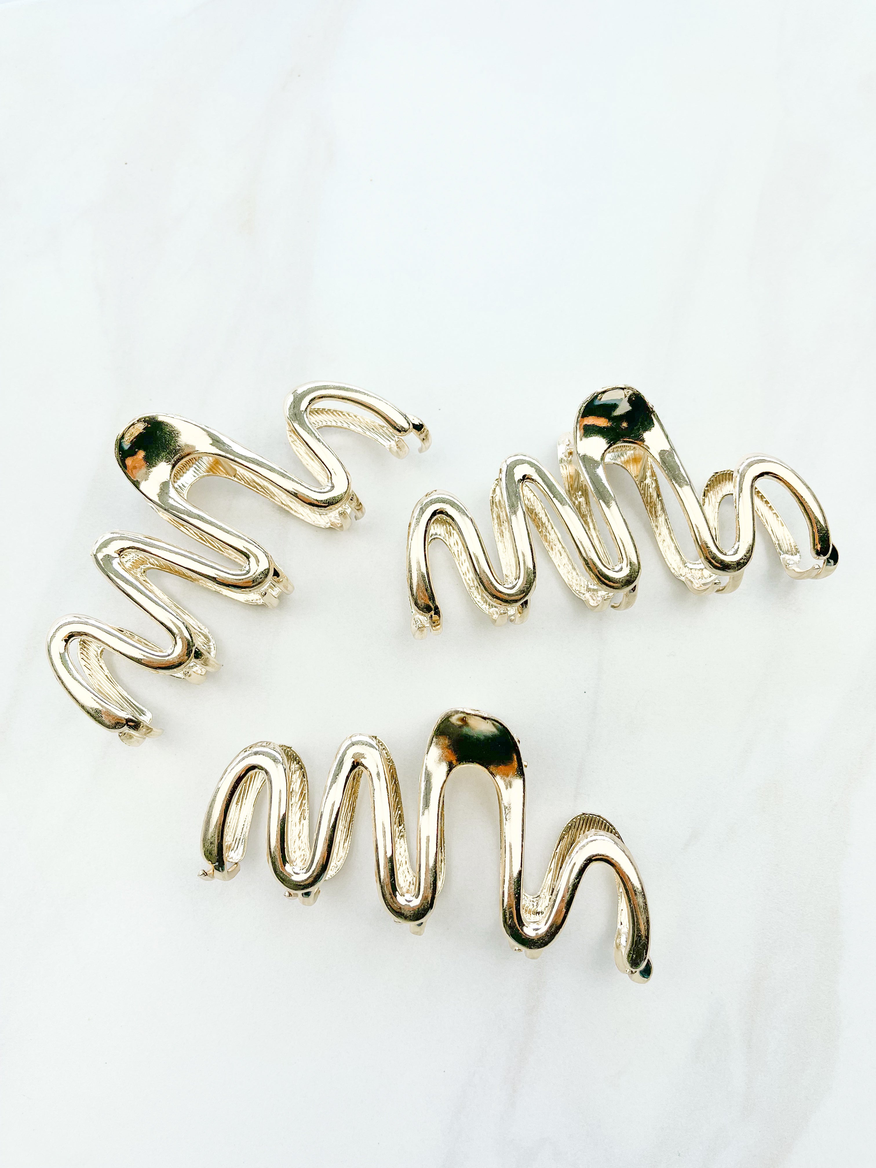 A group of zig zag-shaped gold hair clips.