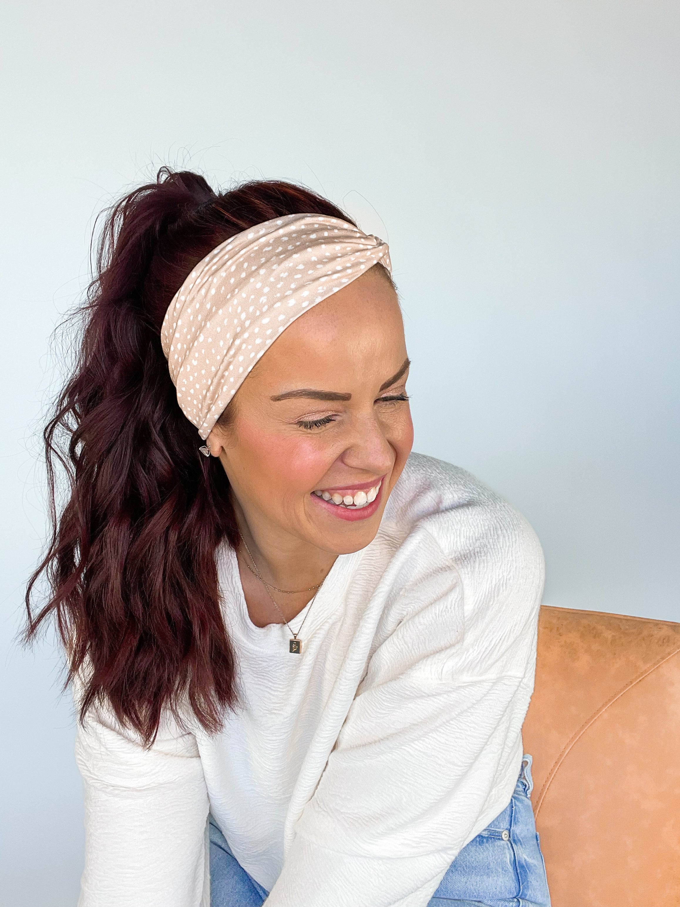 A woman wearing a Chai Latte headband, smiling confidently. Versatile 3-in-1 twist style, sweat absorbent, non-slip, perfect for workouts or play.