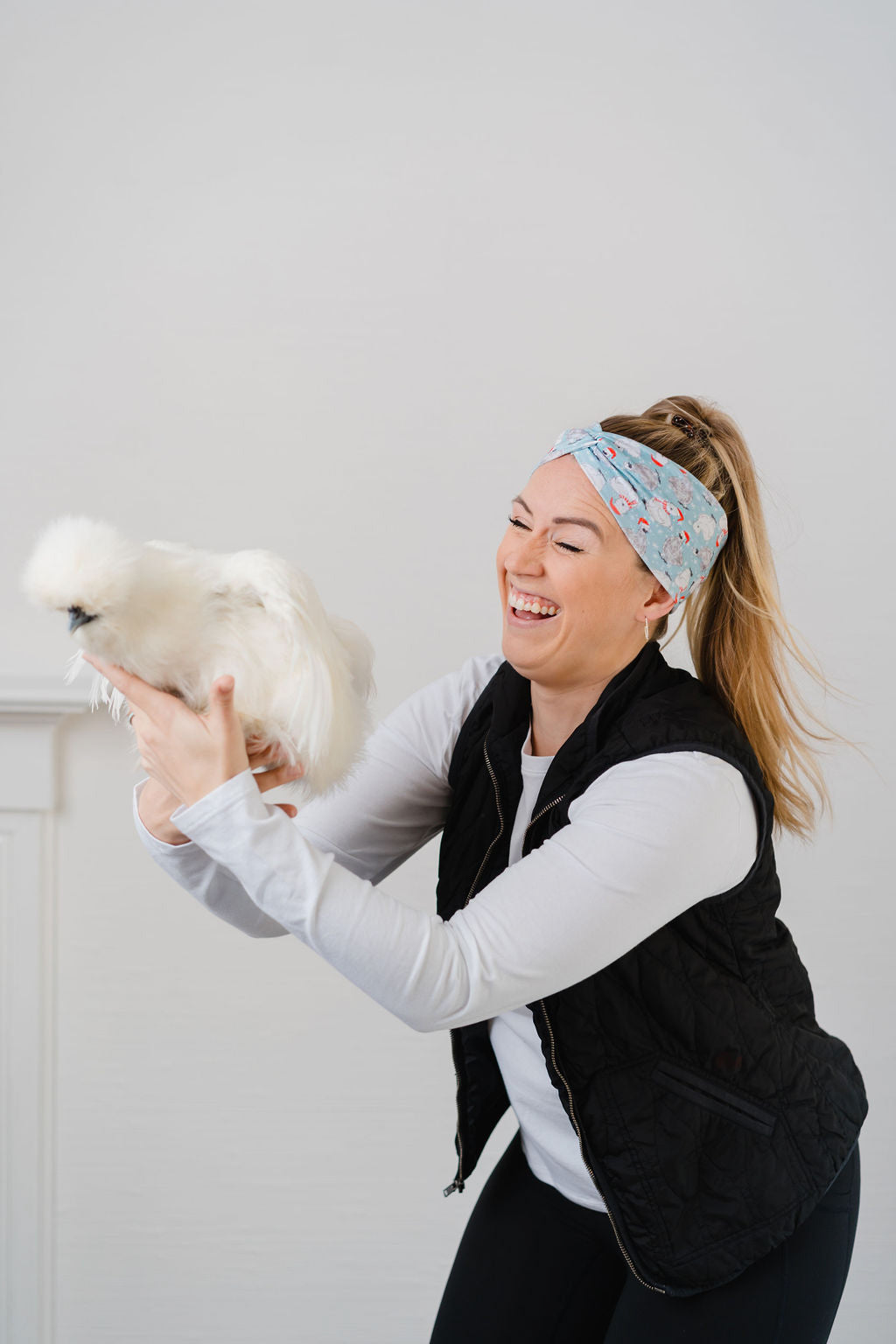 Adult women's light blue headband with white snowflakes and black and white Silkie chickens with red Santa hats and scarves