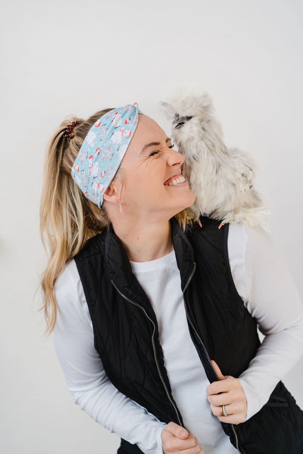 Adult women's light blue headband with white snowflakes and black and white Silkie chickens with red Santa hats and scarves