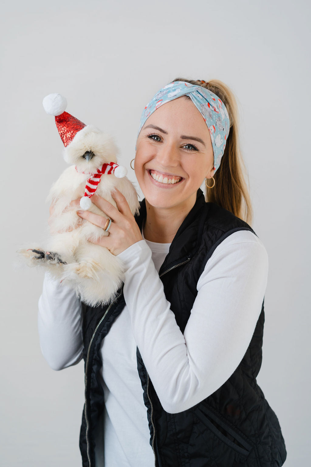 Adult women's light blue headband with white snowflakes and black and white Silkie chickens with red Santa hats and scarves