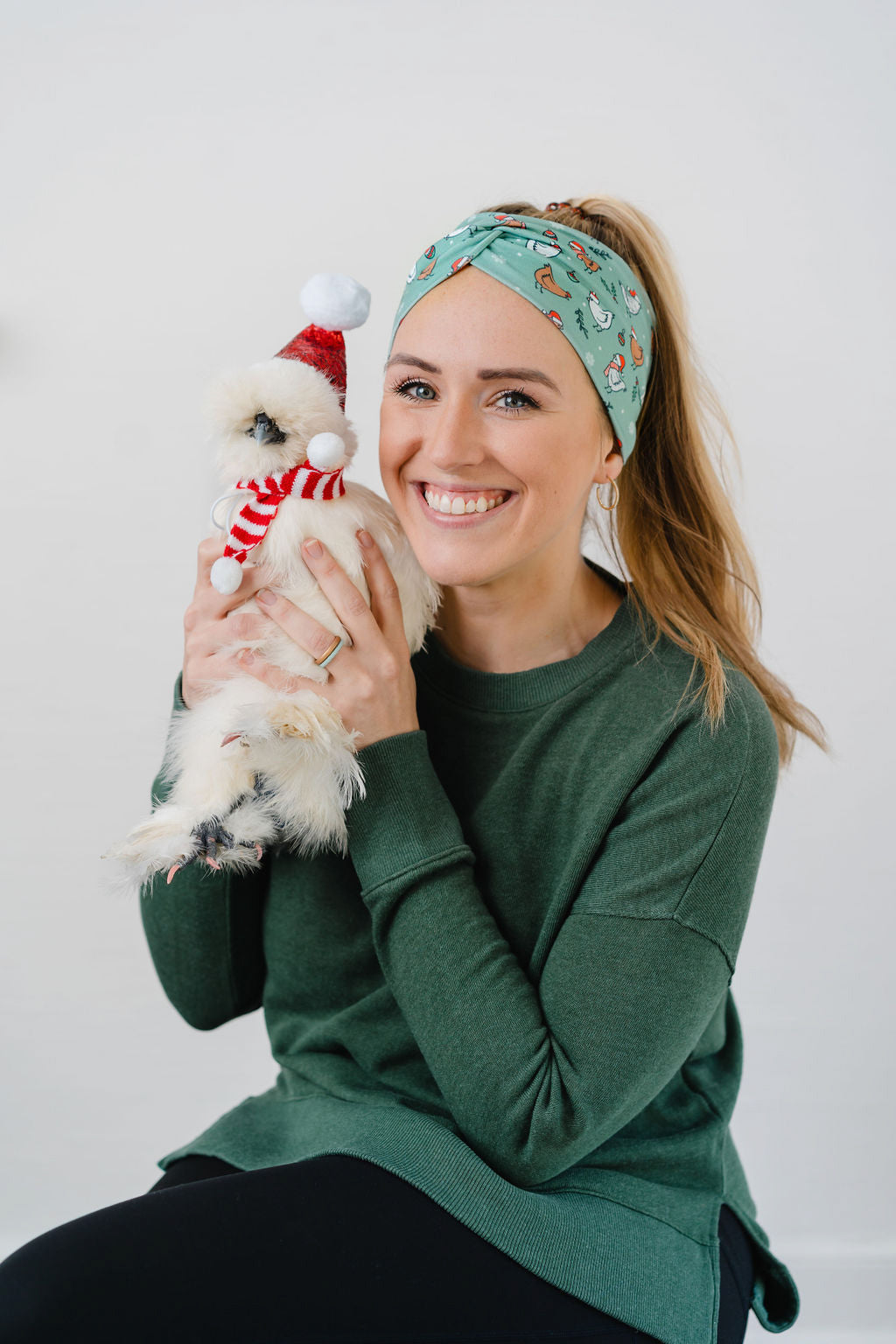 Adult women's light sage headband with brown and white cartoon chickens wearing red Santa hats and scarves, mistletoe and snowflakes