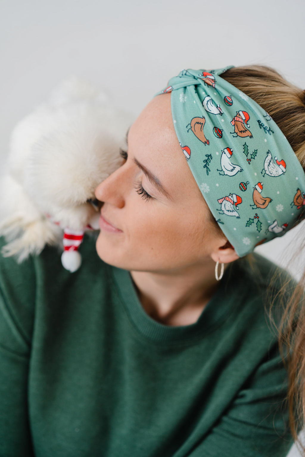 Adult women's light sage headband with brown and white cartoon chickens wearing red Santa hats and scarves, mistletoe and snowflakes