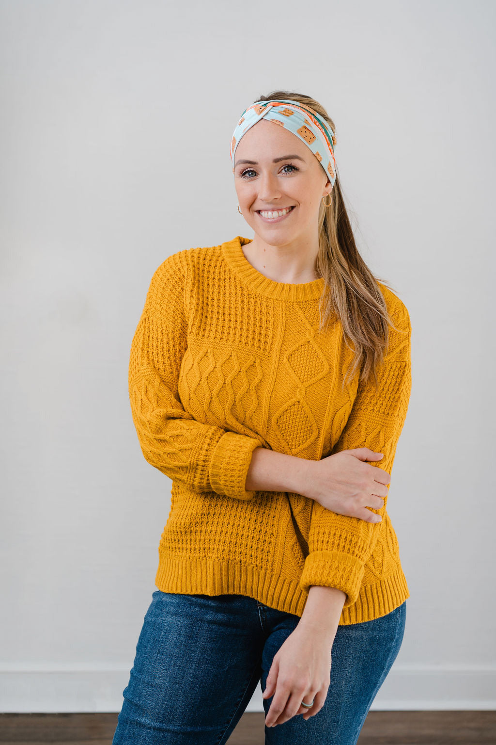 Women wearing the Unfrosted Poptart light blue headband with a wavy rainbow of teal, orange and coral and unfrosted pop-tarts with the words "you unfrosted pop-tart" in cursive