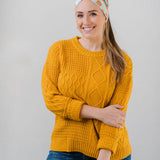 Women wearing the Unfrosted Poptart light blue headband with a wavy rainbow of teal, orange and coral and unfrosted pop-tarts with the words "you unfrosted pop-tart" in cursive