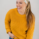 Women wearing the Unfrosted Poptart light blue headband with a wavy rainbow of teal, orange and coral and unfrosted pop-tarts with the words "you unfrosted pop-tart" in cursive