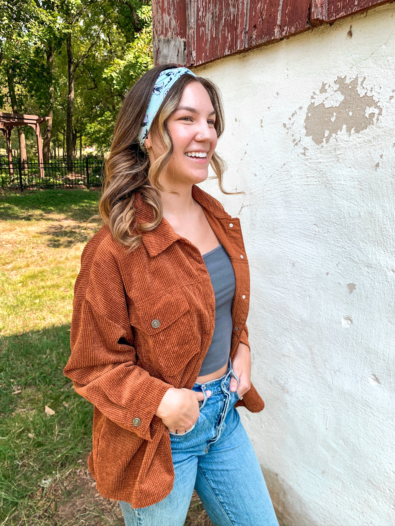 Woman smiling, wearing the Purranormal Activity headband from Lilac Market, featuring a versatile 3-in-1 twist style and buttery-soft, ultra-stretchy poly-knit blend.