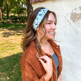 Woman smiling, wearing the Purranormal Activity headband from Lilac Market, featuring a versatile 3-in-1 twist style and buttery-soft, ultra-stretchy poly-knit blend.