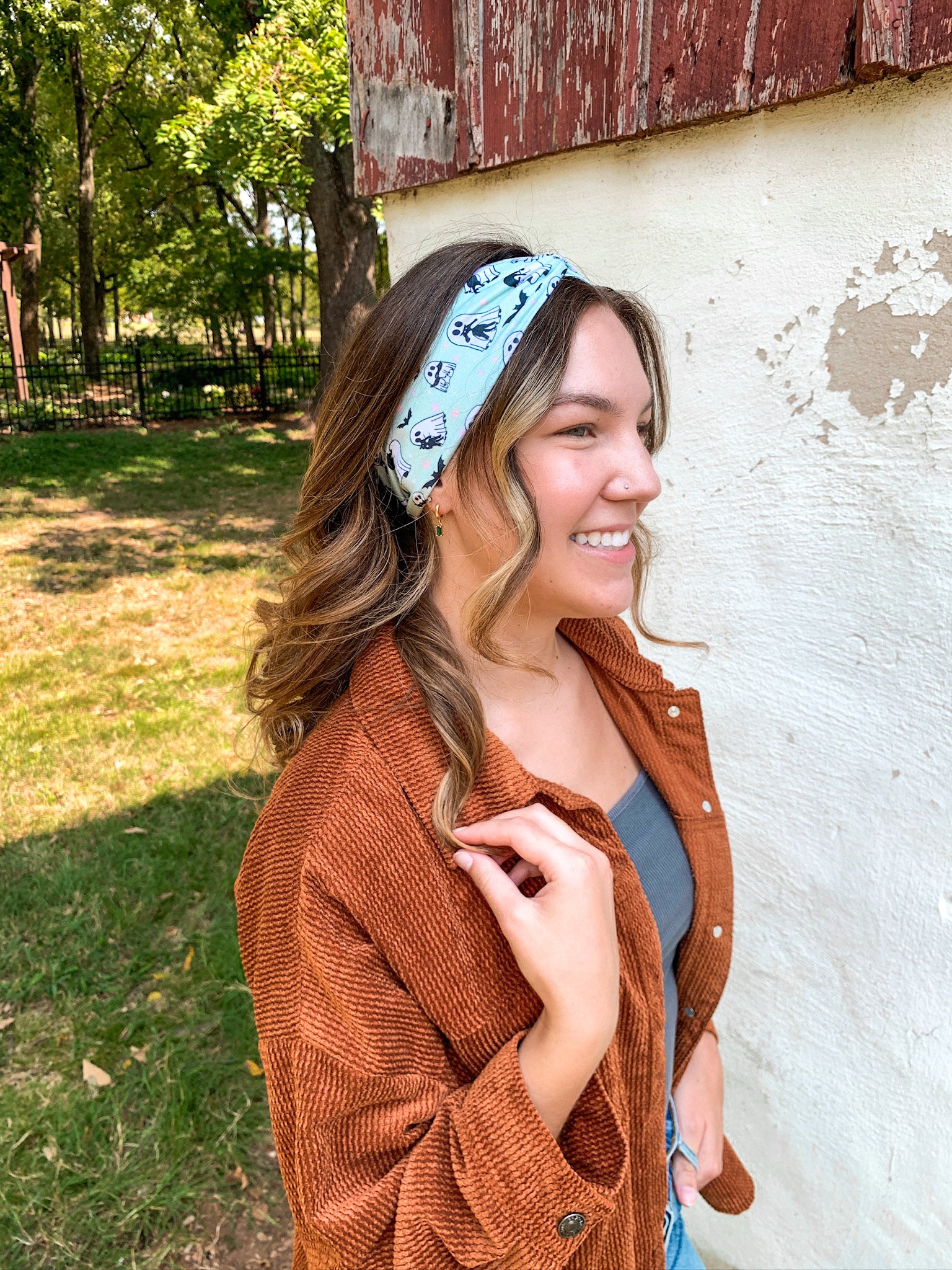 Woman smiling, wearing the Purranormal Activity headband from Lilac Market, featuring a versatile 3-in-1 twist style and buttery-soft, ultra-stretchy poly-knit blend.