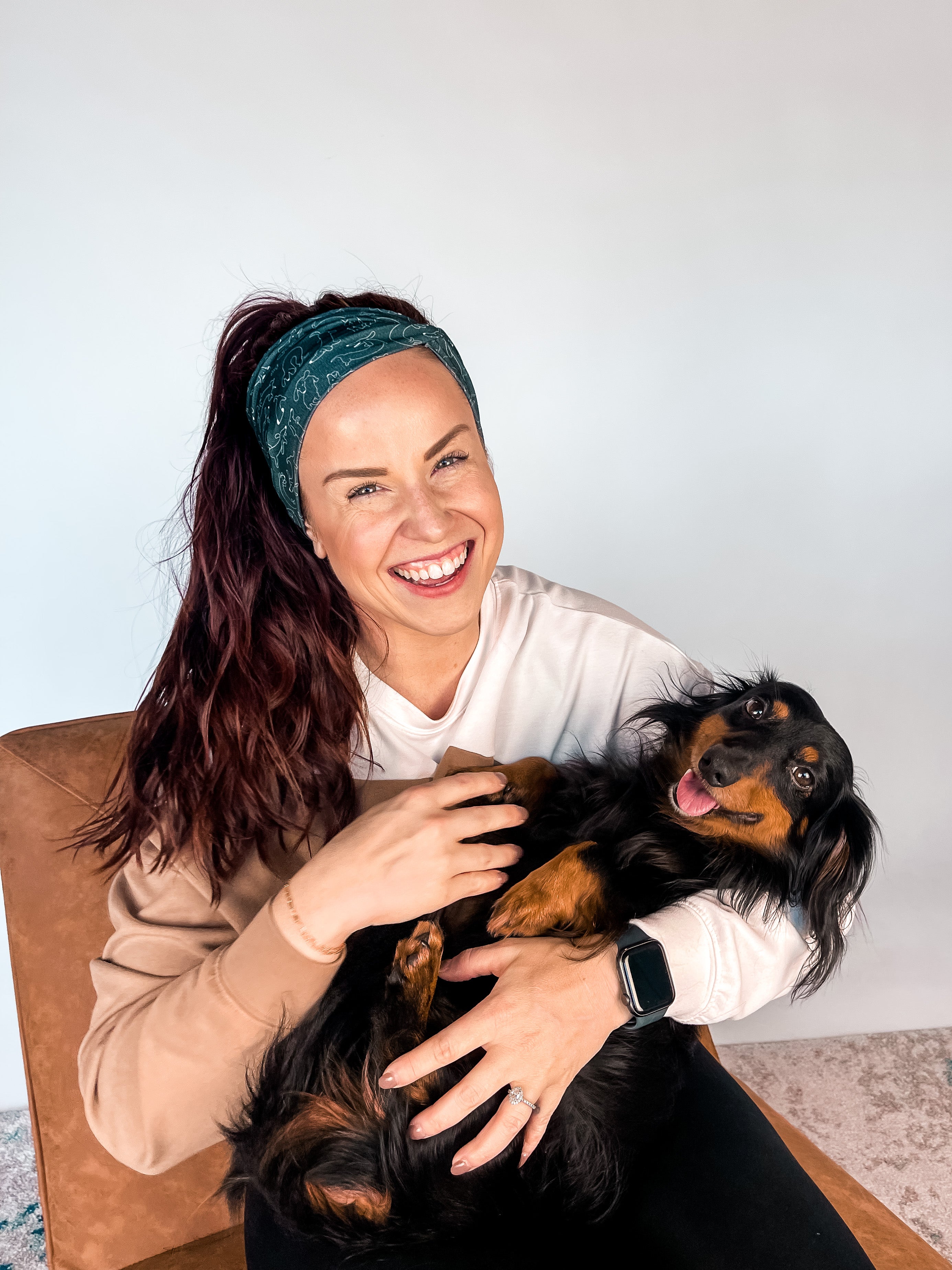 Adult women's black headband with white drawn outline of a playful Dachshund dog