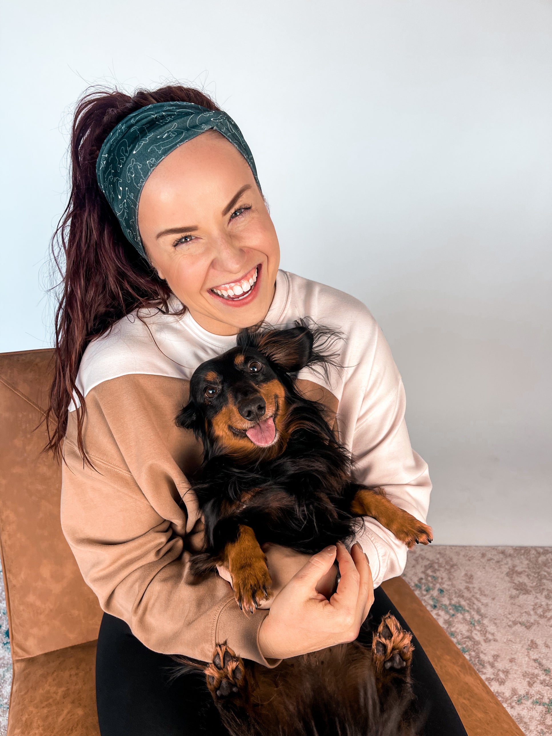 Adult women's black headband with white drawn outline of a playful Dachshund dog