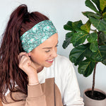 Adult women's dark green headband with teal elephants and greenery, pink tusks and legs and flowers