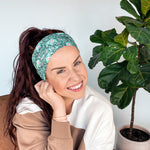 Adult women's dark green headband with teal elephants and greenery, pink tusks and legs and flowers