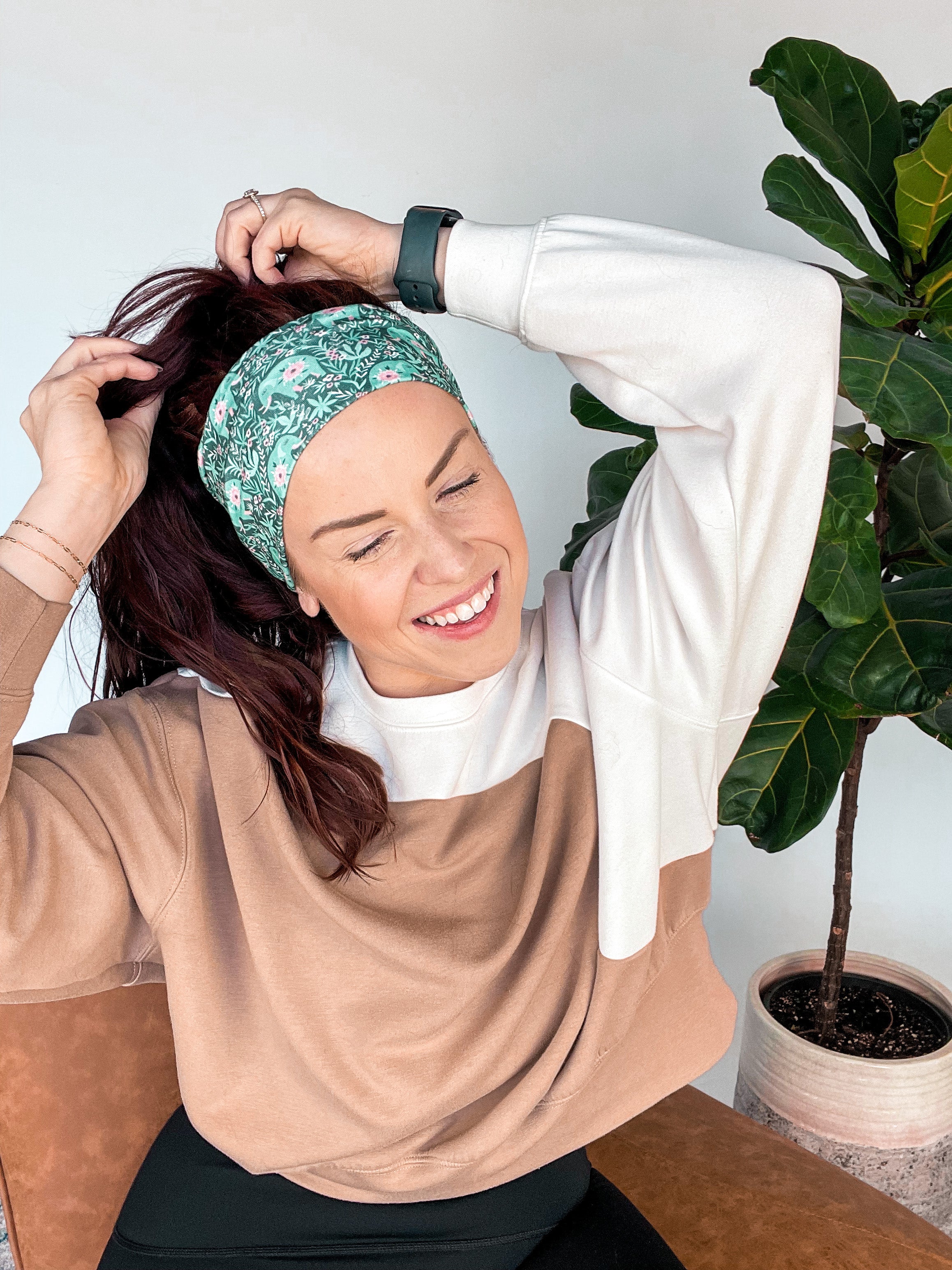 Adult women's dark green headband with teal elephants and greenery, pink tusks and legs and flowers