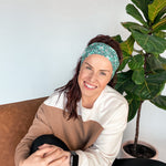 Adult women's dark green headband with teal elephants and greenery, pink tusks and legs and flowers