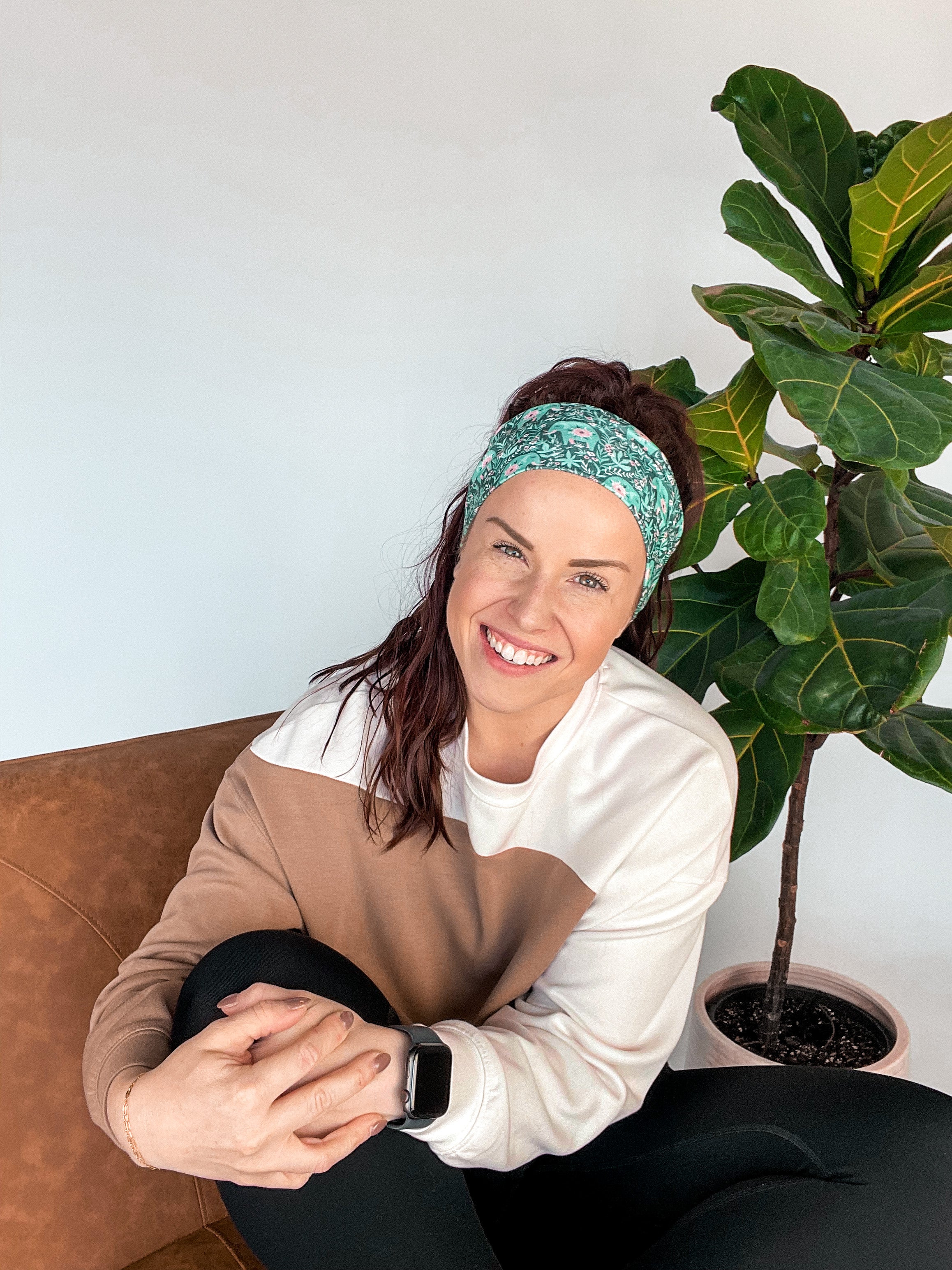 Adult women's dark green headband with teal elephants and greenery, pink tusks and legs and flowers