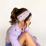 Woman in workout gear wearing the You Give Me Tachycardia headband, showcasing its versatile 3-in-1 twist style and non-slip, buttery-soft poly-knit blend.