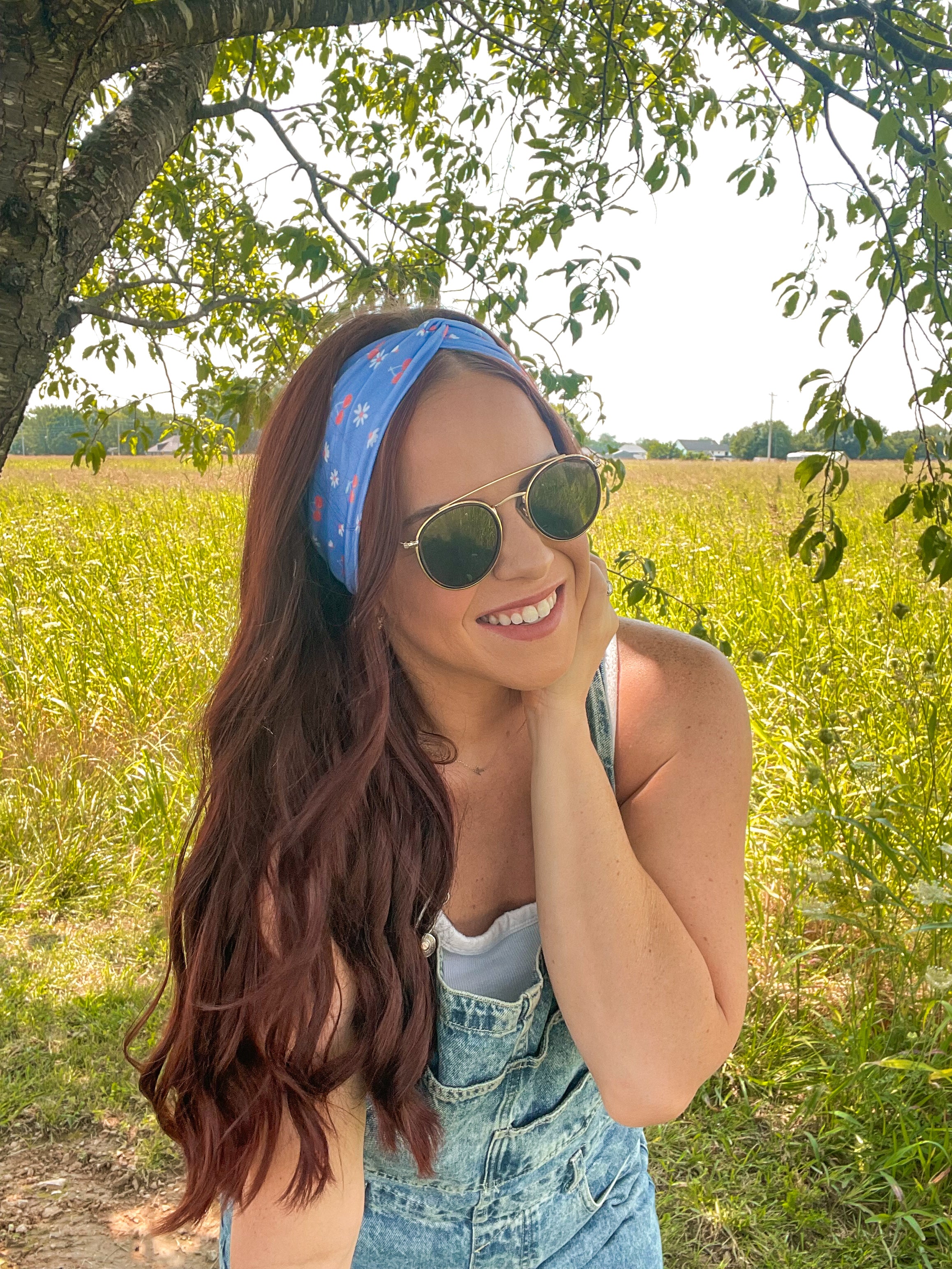 Woman in sunglasses confidently wearing the Cherry on Top headband, designed for comfort, versatility, and functionality.