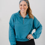 Woman wearing the Science Skunk black headband with artistic black and white skunk and teal, gold, pink and white allover flowers