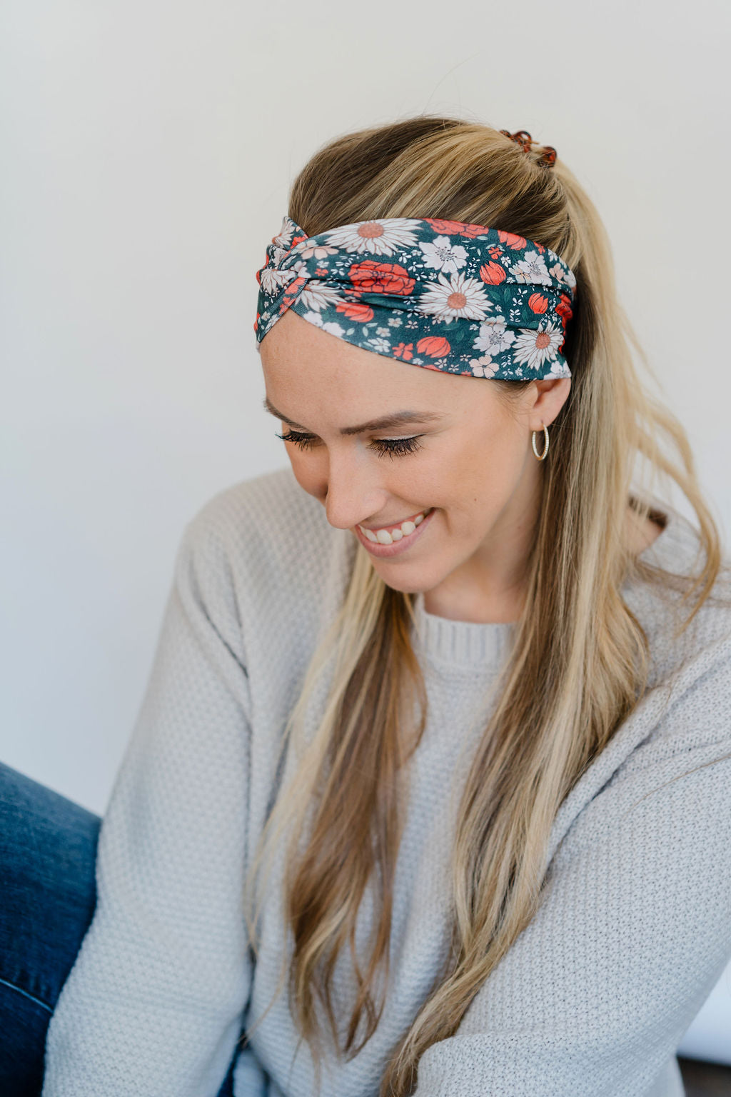Adult women's dark forest green headband with red, white, and beige Christmas flowers
