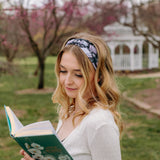 A woman with blonde hair wearing a Uniquely Magic headband, showcasing a versatile 3-in-1 twist style. Functional, machine washable, sweat absorbent, and non-slip for workouts, shifts, or play.