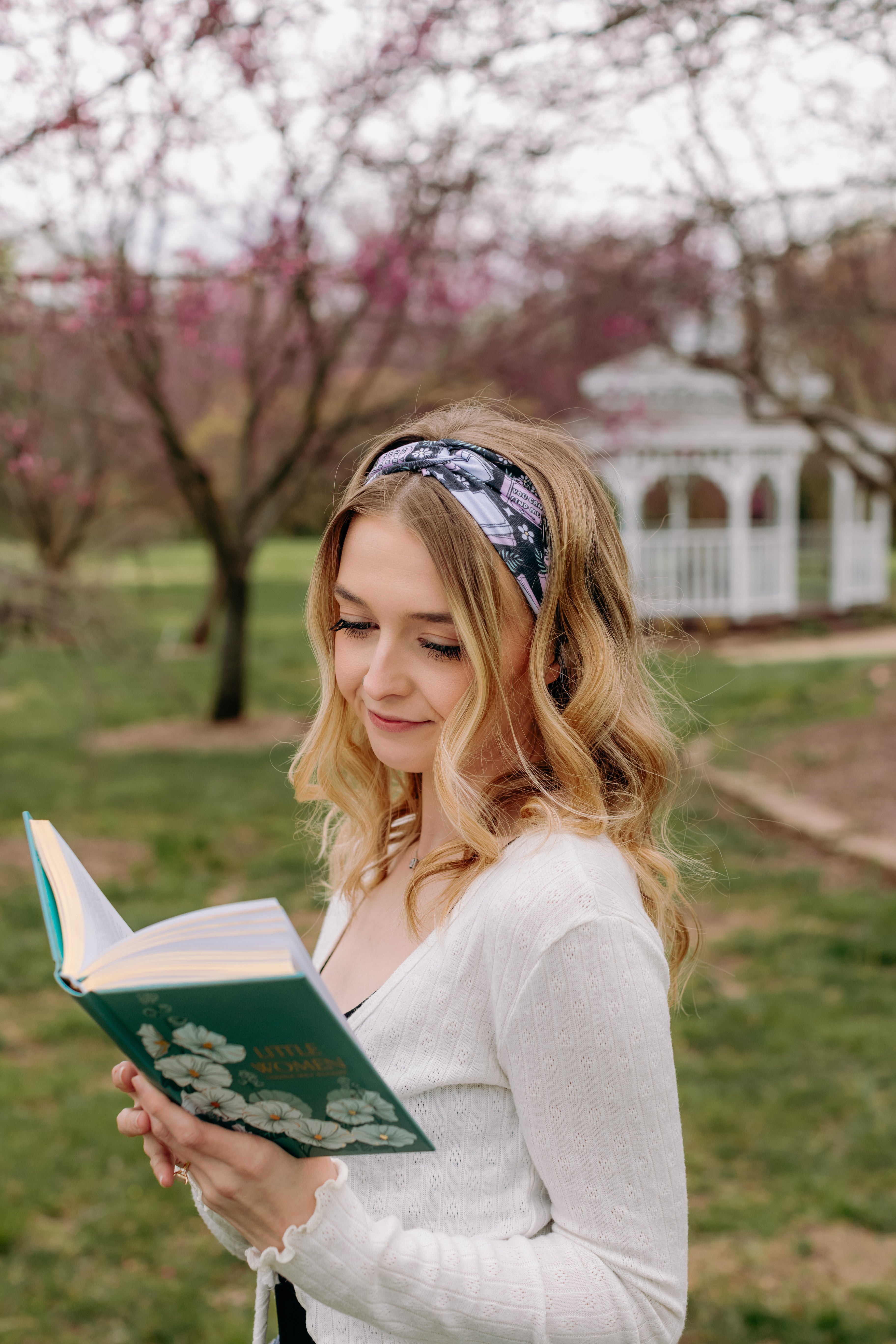 A woman with blonde hair wearing a Uniquely Magic headband, showcasing a versatile 3-in-1 twist style. Functional, machine washable, sweat absorbent, and non-slip for workouts, shifts, or play.
