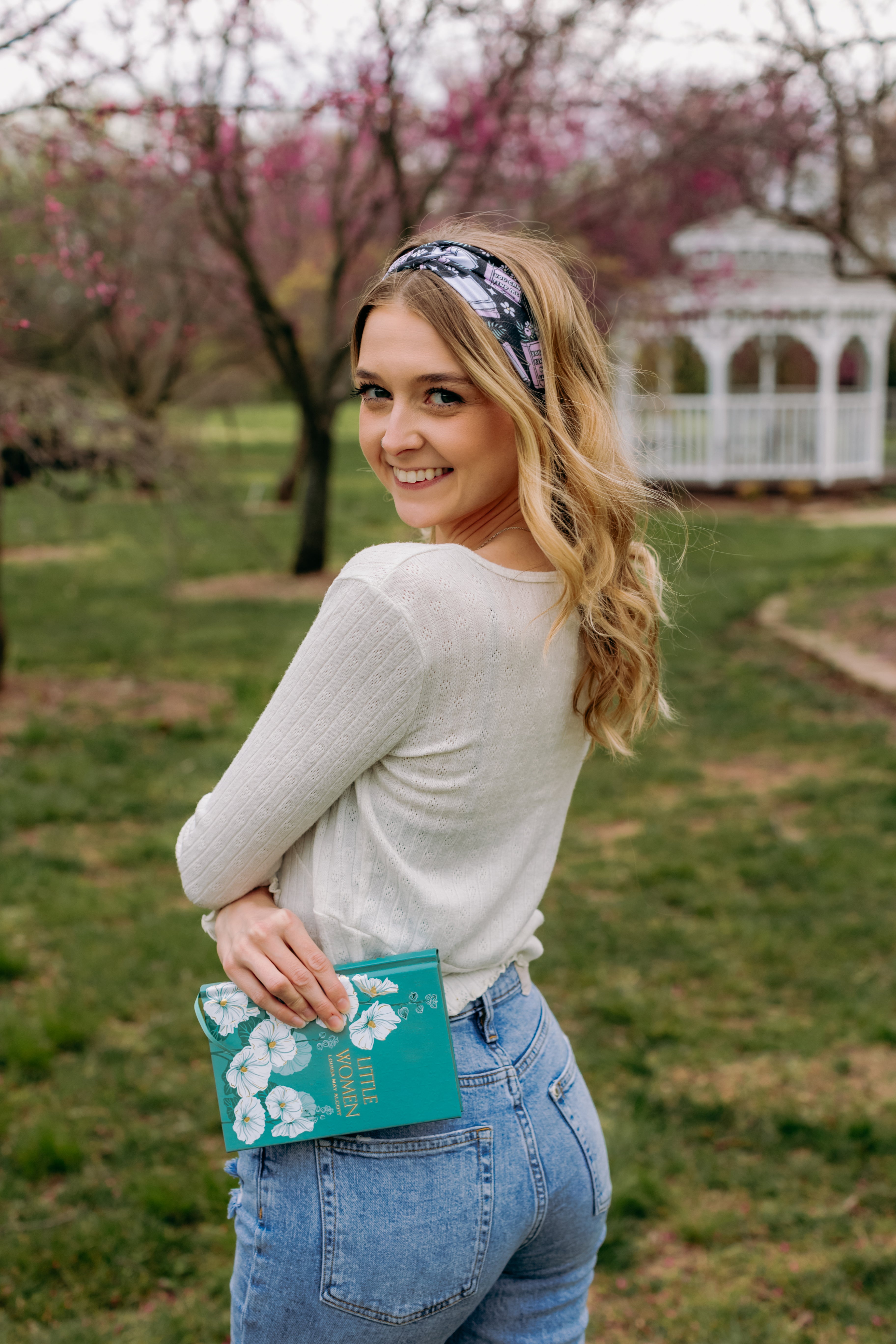 A woman with blonde hair wearing a Uniquely Magic headband, showcasing a versatile 3-in-1 twist style. Functional, machine washable, sweat absorbent, and non-slip for workouts, shifts, or play.