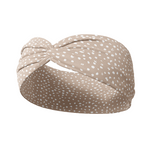 A versatile light beige Chai Latte headband with white natural spots, designed for confidence and function. Features ultra-stretchy poly-knit blend, sweat-absorbent double-layer fabric, and a 3-in-1 twist style. Made in Springfield, MO.