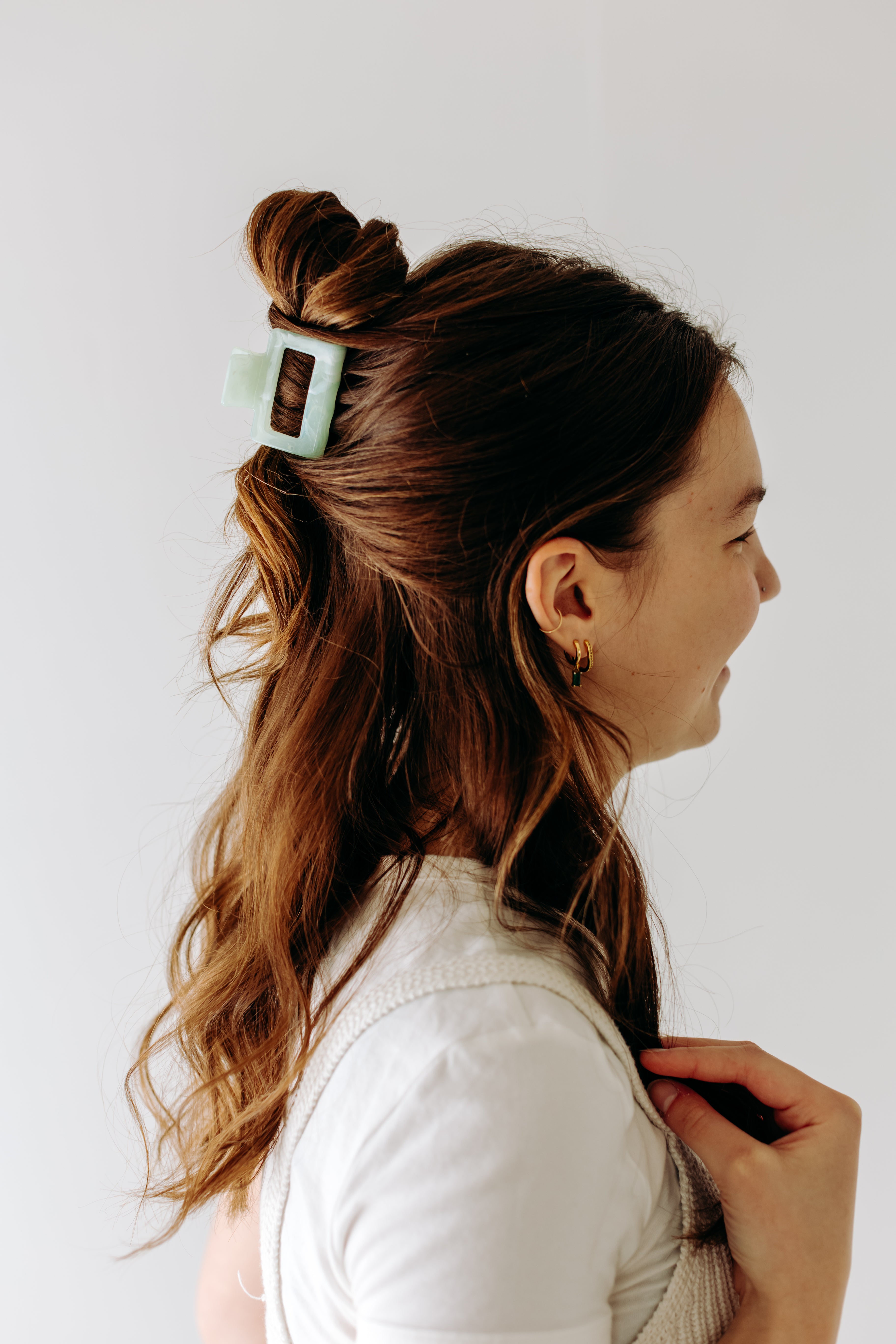 A woman with long hair styled perfectly with the Spring Fling Lilac Clip, showing both fashion and functionality.