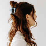 A woman with long hair styled perfectly with the Spring Fling Lilac Clip, showing both fashion and functionality.