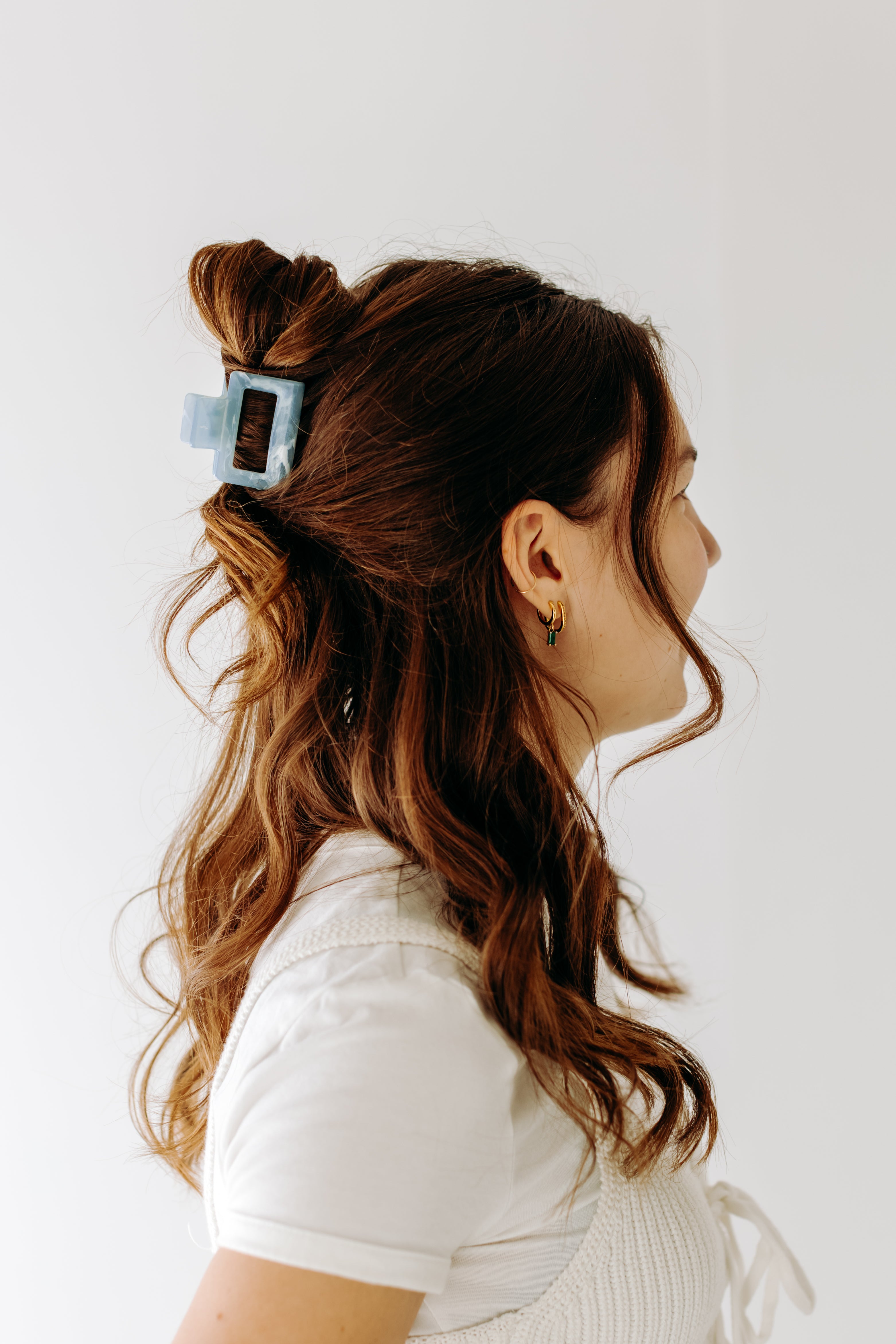 A woman with long hair styled perfectly with the Spring Fling Lilac Clip, showing both fashion and functionality.