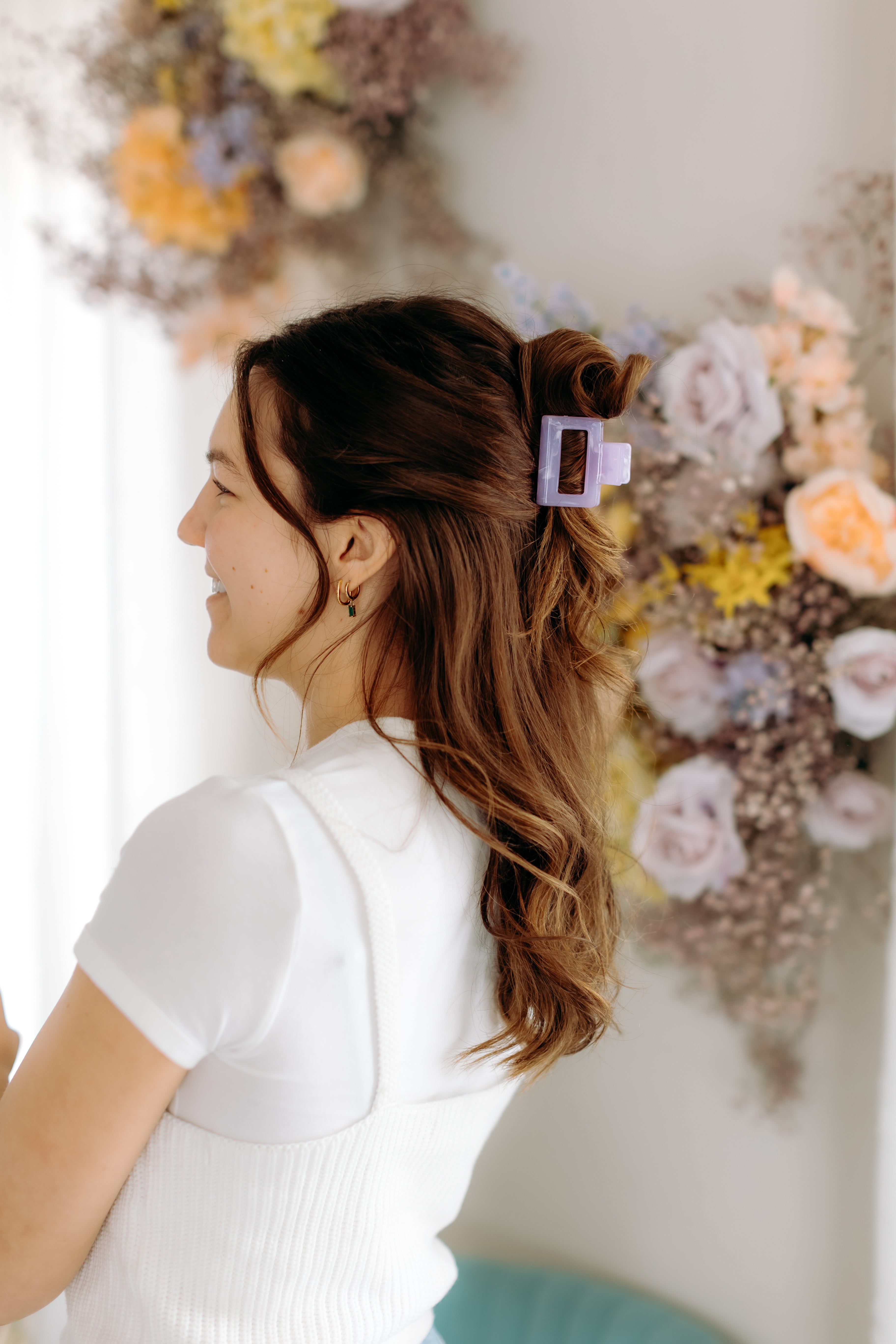 A woman with long hair styled perfectly with the Spring Fling Lilac Clip, showing both fashion and functionality.