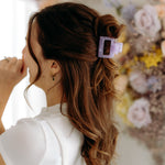 A woman with long hair styled perfectly with the Spring Fling Lilac Clip, showing both fashion and functionality.