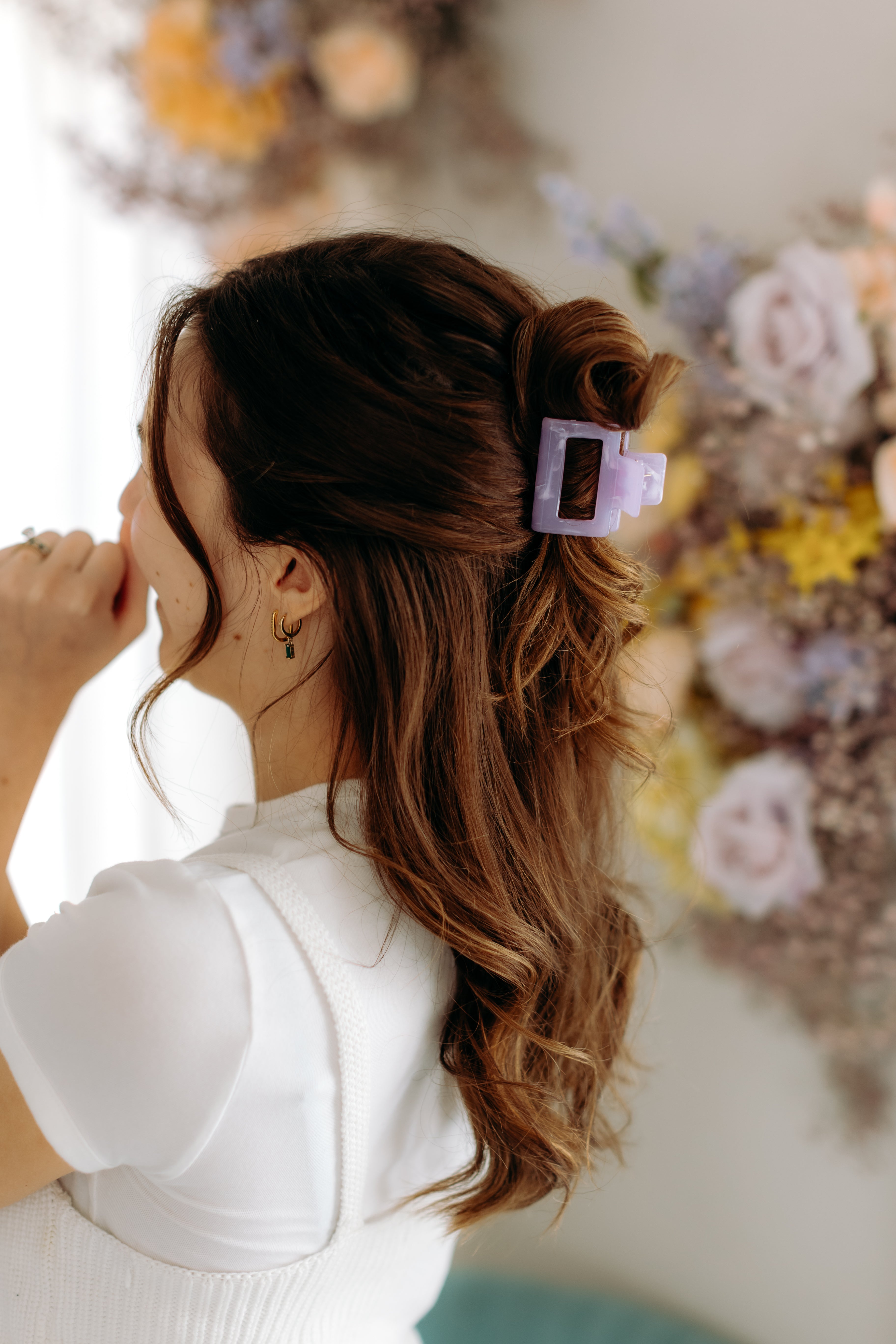 A woman with long hair styled perfectly with the Spring Fling Lilac Clip, showing both fashion and functionality.