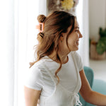 A woman with long hair styled perfectly with the Spring Fling Lilac Clip, showing both fashion and functionality.