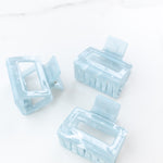 Spring Fling Lilac Clip featuring an opaque square blue clip, 2 inches long, glossy material, metal hinge closure, ideal for keeping hair styled and out of your face.